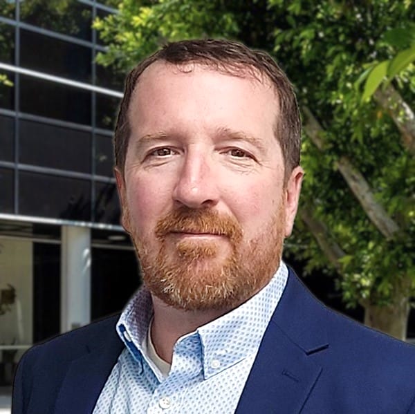 Man in suit outdoors near building.